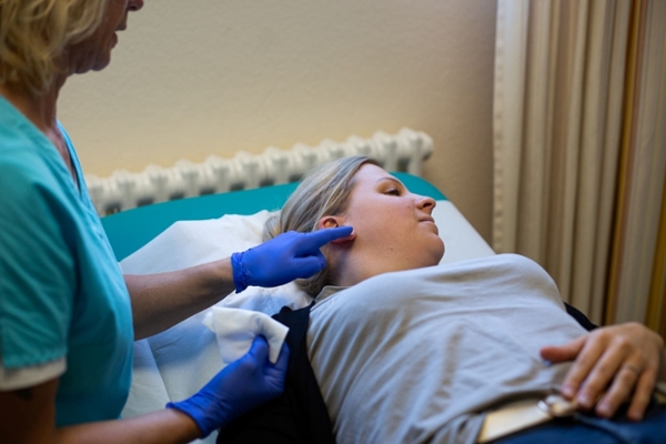 Akupunktur am Ohr einer liegenden Frau Akupunktur am Ohr einer liegenden Frau