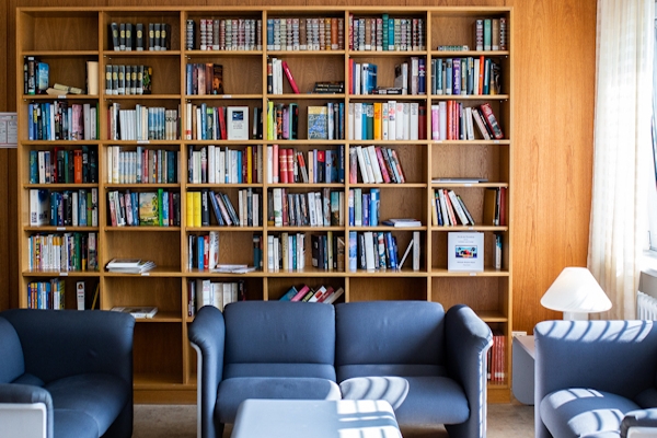 Bibliothek mit vielen Bücher in Regalen und einer Sitzgarnitur Bibliothek mit vielen Bücher in Regalen und einer Sitzgarnitur